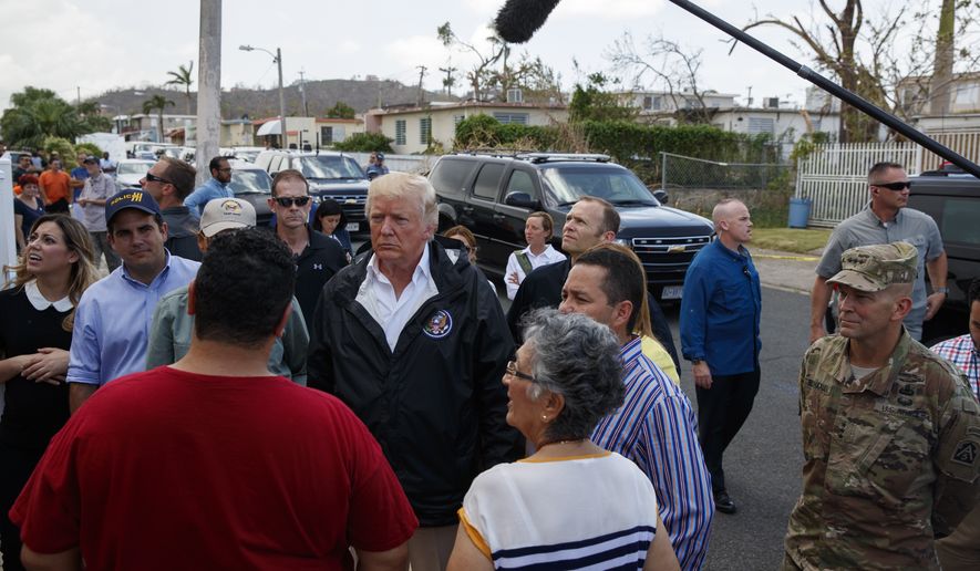 President Donald Trump talks with residents during a tour a neighborhood impacted by Hurricane Maria, Tuesday, Oct. 3, 2017, in Guaynabo, Puerto Rico. (AP Photo/Evan Vucci)