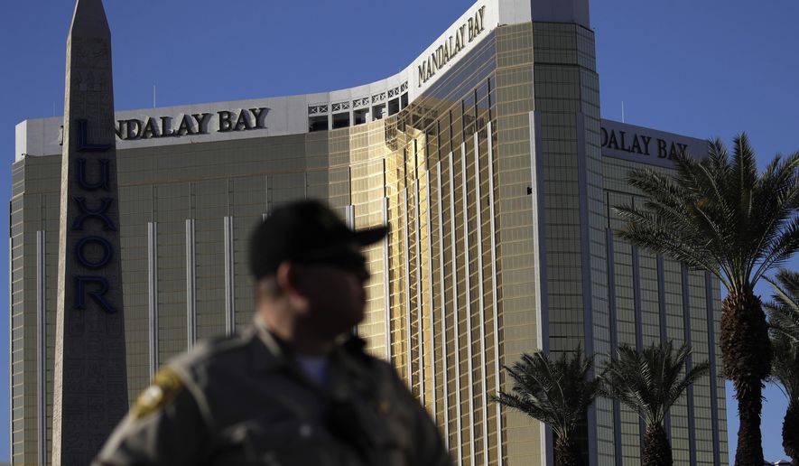 A Las Vegas police officer stands by a blocked off area near the Mandalay Bay casino, Tuesday, Oct. 3, 2017, in Las Vegas. Authorities said Stephen Craig Paddock broke windows on the casino and began firing with a cache of weapons, killing dozens and injuring hundreds at the festival. (AP Photo/John Locher)