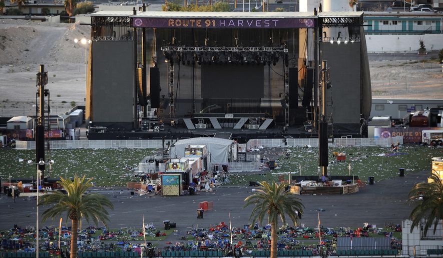 Debris litters a festival grounds across the street from the Mandalay Bay resort and casino Tuesday, Oct. 3, 2017, in Las Vegas. Authorities said Stephen Craig Paddock broke windows on the casino and began firing with a cache of weapons, killing dozens and injuring hundreds at a music festival at the grounds. (AP Photo/John Locher)