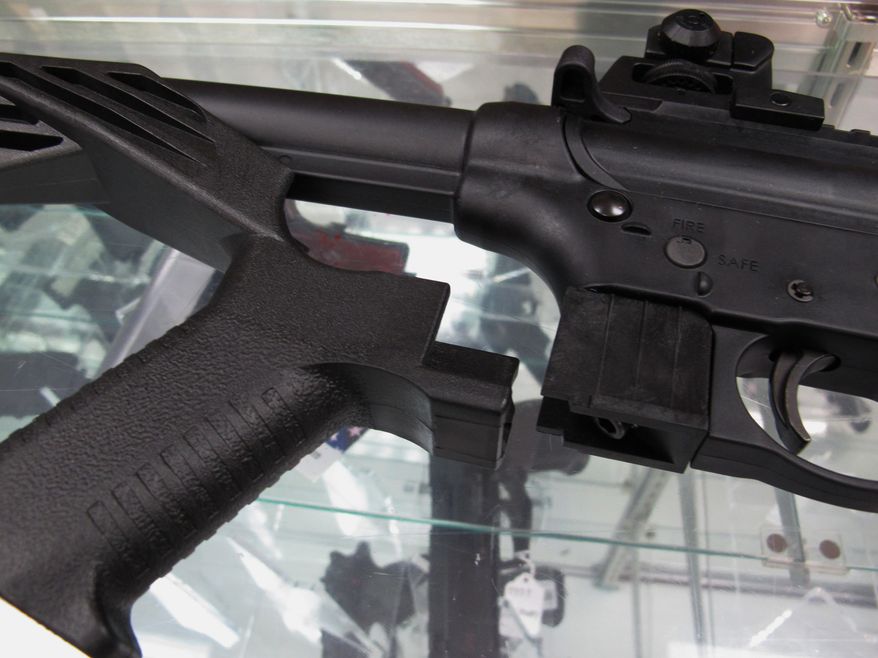 A &quot;bump&quot; stock is displayed next to a disassembled .22-caliber rifle at North Raleigh Guns in Raleigh, North Carolina, Feb. 1, 2013. (AP Photo/Allen Breed) ** FILE **