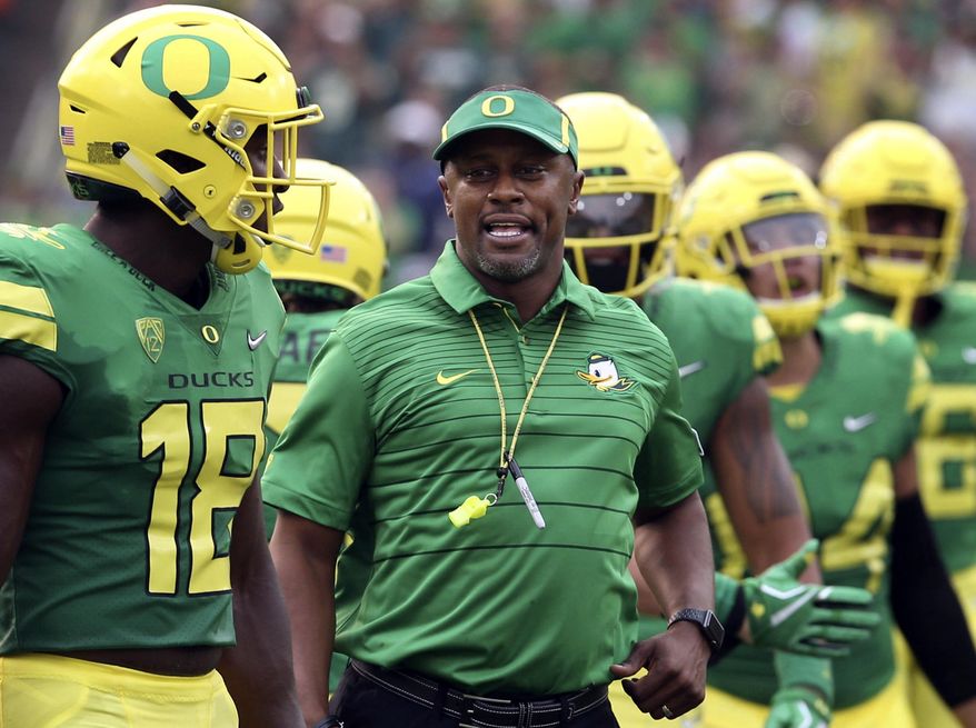 FILE - In this Sept. 2, 2017, file photo, Oregon coach Willie Taggart, center, joins his team as they take the field for an NCAA college football game against Southern Utah in Eugene, Ore. A number of Pac-12 teams are addressing penalty problems going into the halfway mark of the season. Oregon is among the nation's worst teams when it comes to penalties, with UCLA also seeing lots of yellow flags. (AP Photo/Chris Pietsch, File)