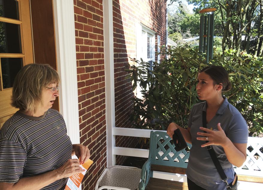 In this Saturday, Sept. 16, 2017, photo, Ashley Klingensmith, right, Pennsylvania field director for Americans for Prosperity, talks with Leora Kirkpatrick about overhauling the tax code, in Wormleysburg, Pa. Even a master salesman like President Donald Trump needs help to convince ordinary people that U.S. corporations desperately need to have their taxes cut. Which is why Klingensmith has been going door-to-door with other canvassers to ask homeowners to support lower taxes for corporations. (AP Photo/Josh Boak)
