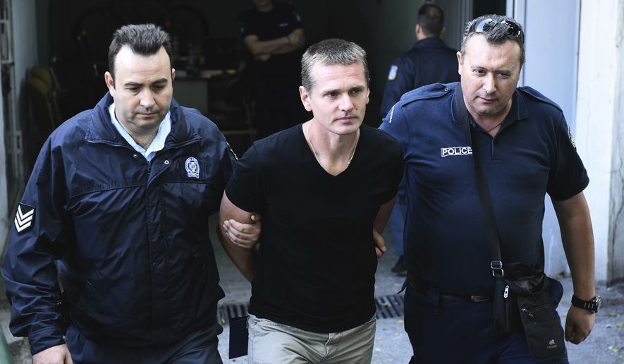 Police officers escorted Alexander Vinnik from a courthouse on Wednesday after a Greek court ruled for extradition to the United States, where he is wanted in connection with a $4 billion bitcoin fraud case. (Associated Press)