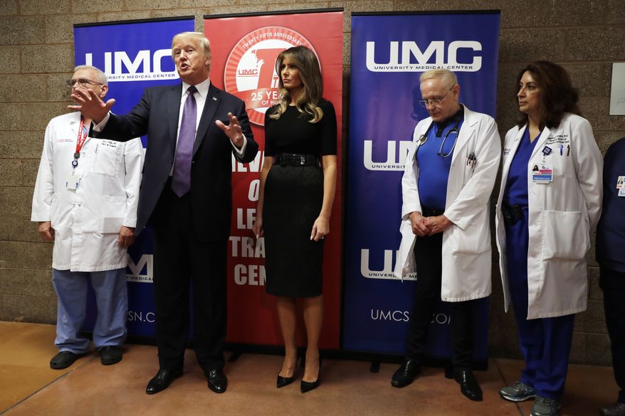 President Donald Trump talks as first lady Melania Trump and surgeon Dr. John Fildes, left, listens at the University Medical Center after Trump met with survivors of the mass shooting Wednesday, Oct. 4, 2017, in Las Vegas. (AP Photo/Evan Vucci)