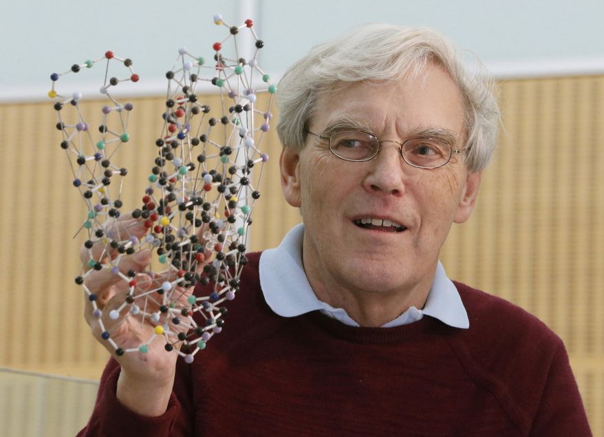 Richard Henderson, one of the 2017 Nobel Prize winners in Chemistry, holds a bacterio rhodopsin model prior to a press conference at the Laboratory of Molecular Biology in Cambridge, England, Wednesday, Oct. 4, 2017. Three researchers based in the U.S., U.K. and Switzerland won the Nobel Prize in Chemistry on Wednesday for developments in electron microscopy. The 9-million-kronor ($1.1 million) prize is shared by Jacques Dubochet of the University of Lausanne, Joachim Frank at New York's Columbia University and Richard Henderson of MRC Laboratory of Molecular Biology in Cambridge, Britain. (AP Photo/Frank Augstein)