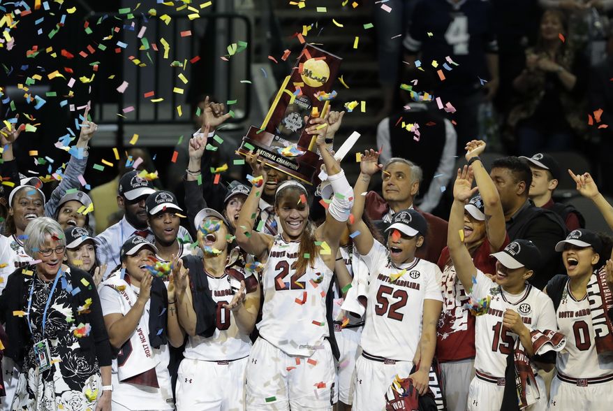 FILE - In this April 2, 2017, file photo, South Carolina forward A'ja Wilson (22) holds up the trophy as she celebrates with teammates after their win over Mississippi State in the final of the NCAA women's Final Four college basketball tournament, in Dallas. Reigning national champion South Carolina leaves behind last year's celebrations and starts preparations this week for a season the Gamecocks hope brings more trophies and cut-down nets their way. (AP Photo/Eric Gay, File)