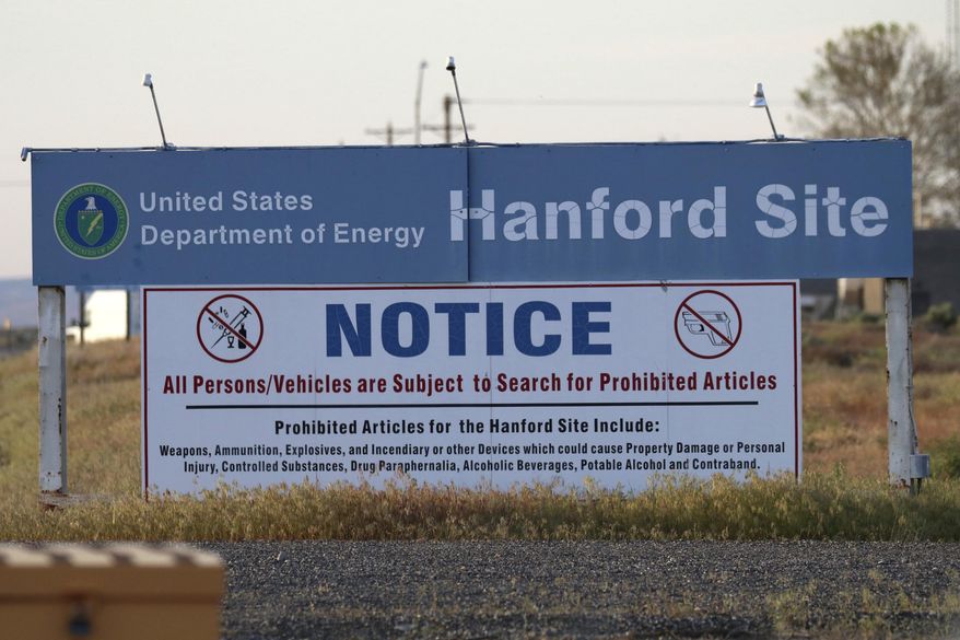 FILE - In this May 9, 2017 file photo, signs are posted by the Hanford Nuclear Reservation in Benton County, in Richland, Wash. The U.S. Department of Energy said Wednesday, Oct. 4, 2017 that workers at Hanford have started injecting grout into a partially collapsed tunnel that contains radioactive wastes left over from the production of nuclear weapons. (AP Photo/Manuel Valdes, File)