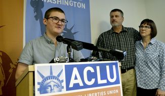 Paxton Enstad, left, addresses a news conference about a lawsuit filed over refusal by an insurance plan to cover his gender-reassignment surgery as his parents, Cheryl and Mark Enstad, look on Thursday, Oct. 5, 2017, in Seattle. The American Civil Liberties Union of Washington filed the discrimination lawsuit against PeaceHealth in federal court on behalf of Cheryl Enstad, of Bellingham, and her son. The lawsuit cites violations of the federal Affordable Care Act as well as Washington state anti-discrimination law. (AP Photo/Elaine Thompson)