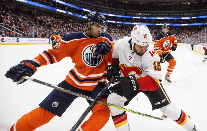 Calgary Flames' Tanner Glass (15) and Edmonton Oilers' Darnell Nurse (25) battle in the corner during the third period of an NHL hockey game Wednesday, Oct. 4, 2017, in Edmonton, Alberta. (Jason Franson/The Canadian Press via AP)