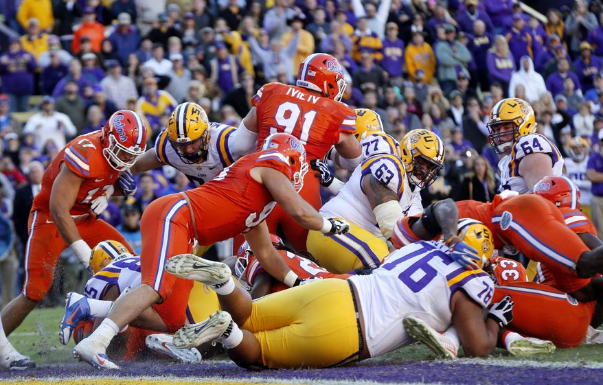 FILE - In this Nov. 19, 2016, file photo,Florida stops LSU at the goal line on the final play of the game as time expires in the second half an NCAA college football game in Baton Rouge, La. Florida won 16-10. Hurricane Matthew’s football fallout concludes Saturday, when reeling LSU plays at 21st-ranked Florida in a game that was switched from Baton Rouge to Gainesville. (AP Photo/Gerald Herbert, File)