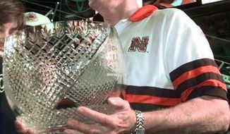 FILE - In this Jan. 2, 1998, file photo, Nebraska coach Tom Osborne holds the Orange Bowl trophy after defeating Tennessee at Pro Player Stadium in Miami. This weekend, players, coaches and staff members from the ’97 team are expected to be on hand for their 20-year reunion, and they’ll attend Saturday night’s, Oct. 7, 2017, game against ninth-ranked Wisconsin. (AP Photo/Susan Walsh, File)