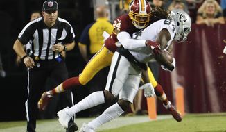 FILE - In this Sept. 24, 2017, file photo, Washington Redskins cornerback Josh Norman (24) ties up Oakland Raiders wide receiver Cordarrelle Patterson (84) during the first half of an NFL football game in Landover, Md. The banged-up Washington Redskins are 2-2 at their bye week and have shown glimpses of being a playoff contender. Injuries to cornerback Josh Norman and left tackle Trent Williams are concerning, but if they’re healthy the Redskins could contend for the NFC East title. (AP Photo/Pablo Martinez Monsivais, File)