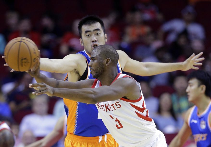 Shanghai Sharks center Zhang Zhaoxu (23) tries to defend against the pass by Houston Rockets guard Chris Paul (3) in the first half of an NBA exhibition basketball game Thursday, Oct. 5, 2017, in Houston. (AP Photo/Michael Wyke)