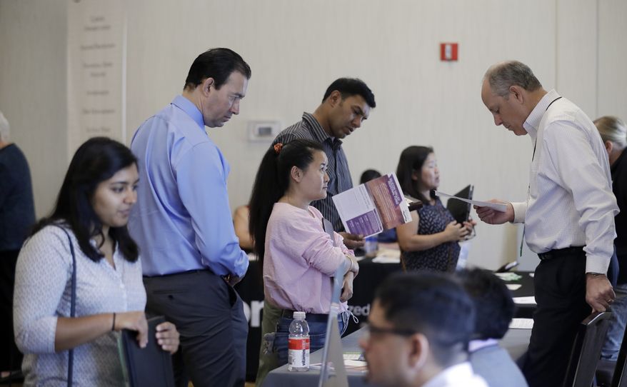 In this Thursday, Aug. 24, 2017, file photo, Phil Wiggett, right, a recruiter with the Silicon Valley Community Foundation, looks at a resume during a job fair in San Jose, Calif. On Friday, Oct. 6, 2017, the U.S. government issues the September jobs report. (AP Photo/Marcio Jose Sanchez)