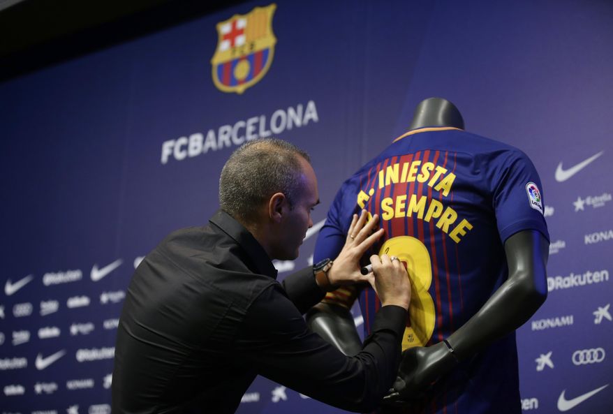 FC Barcelona's Andres Iniesta signs a shirt reading in Catalan: "Andres Iniesta forever" at the Camp Nou stadium in Barcelona, Spain, Friday, Oct. 6, 2017. Barcelona has extended Andres Iniesta's contract "for life.". (AP Photo/Manu Fernandez)