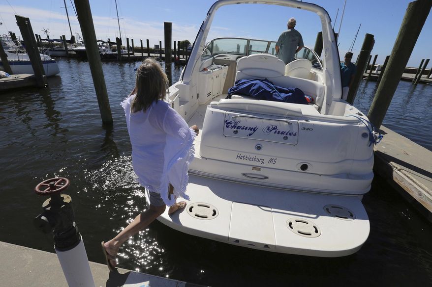 Brenda Kent jumps on her boat as she and her husband leave the Biloxi Small Craft Harbor in Biloxi, Miss., on Friday, Oct. 6, 2017 to take the boat up river in advance of Tropical Storm Nate. Gulf Coast residents were bracing Friday for a fast-moving blast of wind, heavy rain and rising water as Tropical Storm Nate threatened to reach hurricane strength before a weekend landfall. (John Fitzhugh/The Sun Herald via AP)