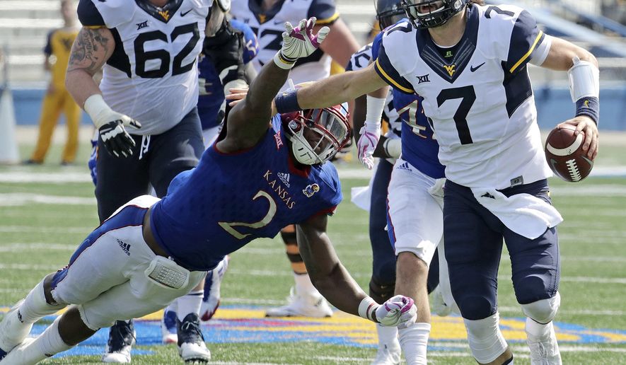 FILE - In this Sept. 23, 2017, file photo, West Virginia quarterback Will Grier (7) evades Kansas defensive end Dorance Armstrong Jr. (2) as he runs for a first down during the second half of an NCAA college football game in Lawrence, Kan. Grier and TCU's Kenny Hill took similar paths to the Big 12, and their head-to-head matchup is the only game Saturday matching two Top 25 teams.(AP Photo/Charlie Riedel, File)