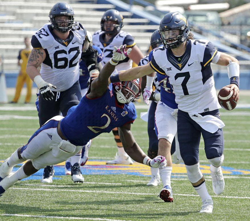 FILE - In this Sept. 23, 2017, file photo, West Virginia quarterback Will Grier (7) evades Kansas defensive end Dorance Armstrong Jr. (2) as he runs for a first down during the second half of an NCAA college football game in Lawrence, Kan. Grier and TCU's Kenny Hill took similar paths to the Big 12, and their head-to-head matchup is the only game Saturday matching two Top 25 teams.(AP Photo/Charlie Riedel, File)