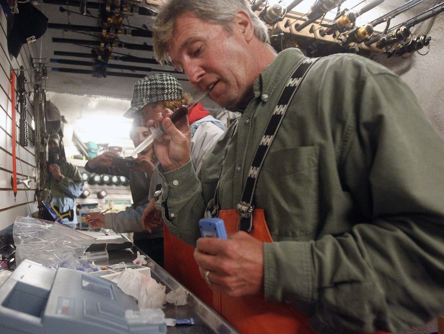 FILE — In this Sept. 13, 2012 file photo, Massachusetts shark expert Greg Skomal pulls the cap off a blood sample taken from an Atlantic great white shark before performing blood gas analysis moments after the nearly 15-foot, 2,292-pound shark was released from the research vessel Ocearch off the coast of Chatham, Mass. Researchers in Massachusetts say great white sharks in the Atlantic Ocean are venturing offshore farther, with more frequency and at greater depths than previously known. The findings were published Sept. 29, 2017, in the scientific journal Marine Ecology Progress Series. (AP Photo/Stephan Savoia, File)