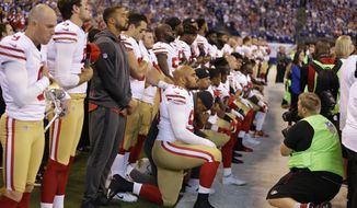Member of the San Francisco 49ers kneel during the playing of the national anthem before an NFL football game against the Indianapolis Colts, Sunday, Oct. 8, 2017, in Indianapolis. (AP Photo/Michael Conroy)
