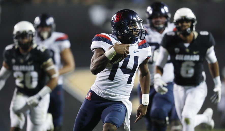 Arizona quarterback Khalil Tate, front, runs for a touchdown past Colorado linebacker Drew Lewis, back left, and defensive back Evan Worthington in the second half of an NCAA college football game Saturday, Oct. 7, 2017, in Boulder, Colo. Arizona won 45-42. (AP Photo/David Zalubowski)