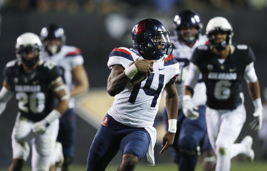 Arizona quarterback Khalil Tate, front, runs for a touchdown past Colorado linebacker Drew Lewis, back left, and defensive back Evan Worthington in the second half of an NCAA college football game Saturday, Oct. 7, 2017, in Boulder, Colo. Arizona won 45-42. (AP Photo/David Zalubowski)