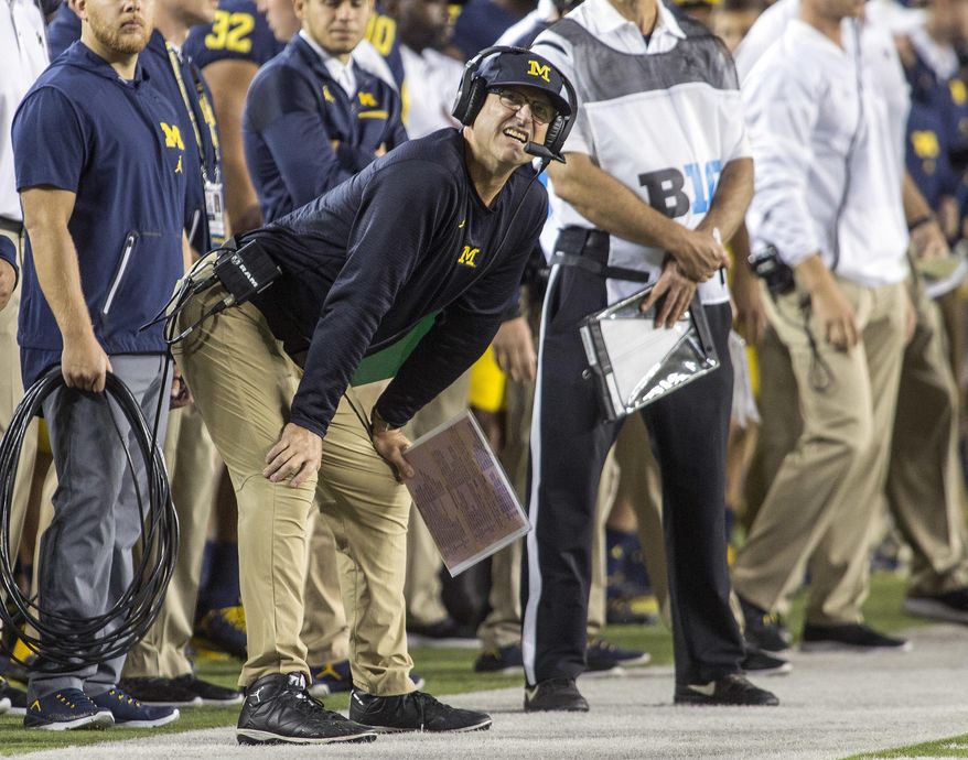 Michigan head coach Jim Harbaugh looks at the scoreboard along the sideline in the first quarter of an NCAA college football game against Michigan State in Ann Arbor, Mich., Saturday, Oct. 7, 2017. (AP Photo/Tony Ding)