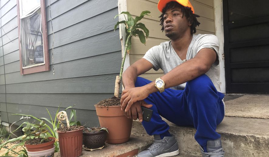 In this June 29, 2017 photo, Joseph Smith, 32, a U.S. Army veteran, sits outside his home in Houston's Freedmen's Town. Smith says he was not offended by NFL players protesting the national anthem. A silent protest initially started by a San Francisco 49ers quarterback Colin Kaepernick last year in response to police killings of minorities has become a measure on patriotism and the nation's symbols, drawing heated responses from some including President Donald Trump. (AP Photo/Russell Contreras)