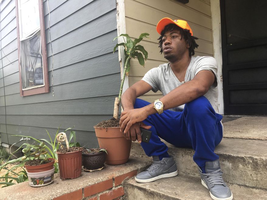 In this June 29, 2017 photo, Joseph Smith, 32, a U.S. Army veteran, sits outside his home in Houston's Freedmen's Town. Smith says he was not offended by NFL players protesting the national anthem. A silent protest initially started by a San Francisco 49ers quarterback Colin Kaepernick last year in response to police killings of minorities has become a measure on patriotism and the nation's symbols, drawing heated responses from some including President Donald Trump. (AP Photo/Russell Contreras)