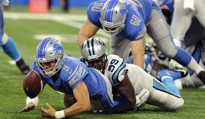Detroit Lions quarterback Matthew Stafford (9) fumbles the ball after a tackle by Carolina Panthers defensive tackle Kawann Short (99) during the second half of an NFL football game, Sunday, Oct. 8, 2017, in Detroit. (AP Photo/Jose Juarez)