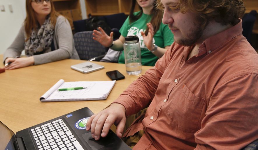 In this Tuesday, Feb. 7, 2017 photo, Penn State University student Jesse Weber, right, looks over his computer as fellow student Amber Morris, center, and program director Katie Tenney, left, exchange ideas during a Stand For State team meeting in State College, Pa. Penn State's Stand for State program is part of a large push in colleges across the country seeking to train people to be able to recognize, and step in, when a sexual assault is unfolding. (AP Photo/Keith Srakocic)