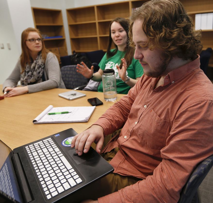 In this Tuesday, Feb. 7, 2017 photo, Penn State University student Jesse Weber, right, looks over his computer as fellow student Amber Morris, center, and program director Katie Tenney, left, exchange ideas during a Stand For State team meeting in State College, Pa. Penn State's Stand for State program is part of a large push in colleges across the country seeking to train people to be able to recognize, and step in, when a sexual assault is unfolding. (AP Photo/Keith Srakocic)