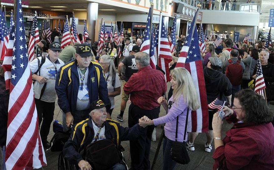 In this Monday, Oct. 2, 2017 file photo, veterans were treated to a big arrival celebration at the Medford airport after returning from an Honor Flight to Washington, D.C. (Andy Atkinson/The Medford Mail Tribune via AP) **FILE**