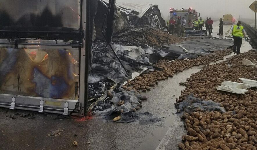 In this image provided by the Louisiana State Police, potatoes lie on Interstate 10 near Butte La Rose, La., on Monday, Oct. 9, 2017. A trucker died in the wreck that engulfed a tractor-trailer in flames and left thousands of potatoes scattered across the interstate. (Louisiana State Police via AP)