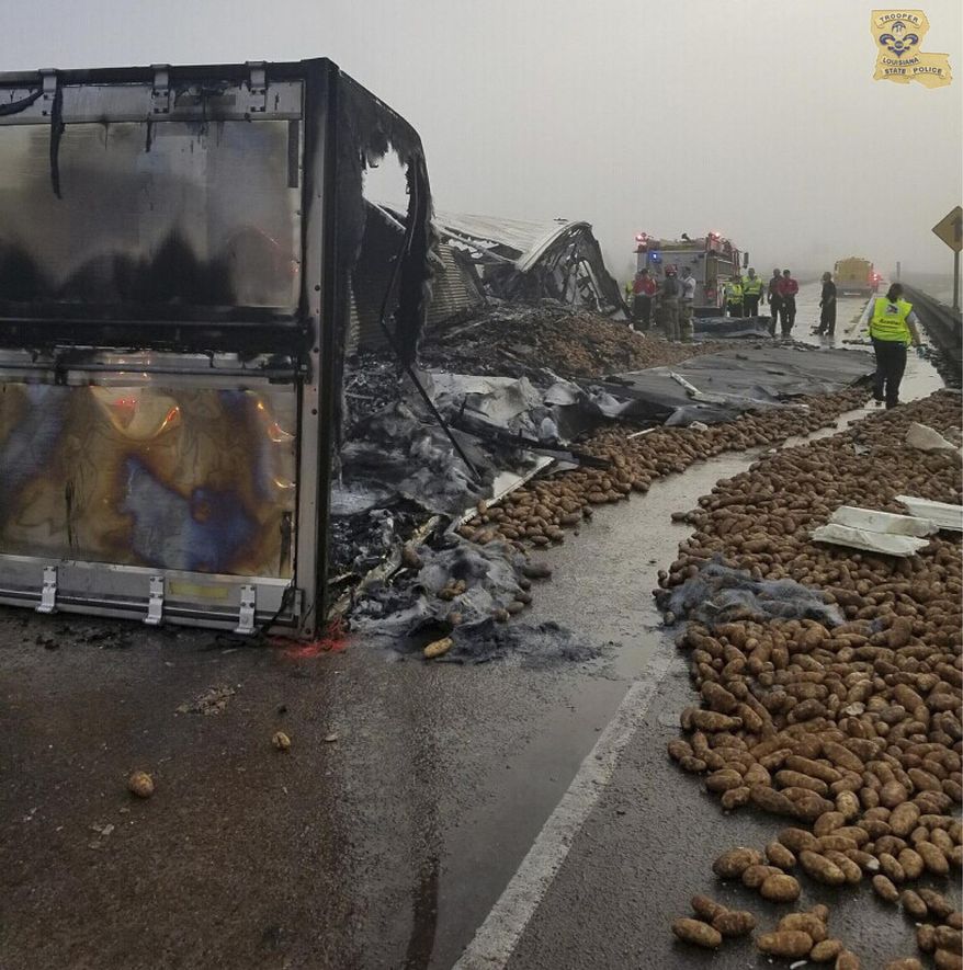 In this image provided by the Louisiana State Police, potatoes lie on Interstate 10 near Butte La Rose, La., on Monday, Oct. 9, 2017. A trucker died in the wreck that engulfed a tractor-trailer in flames and left thousands of potatoes scattered across the interstate. (Louisiana State Police via AP)