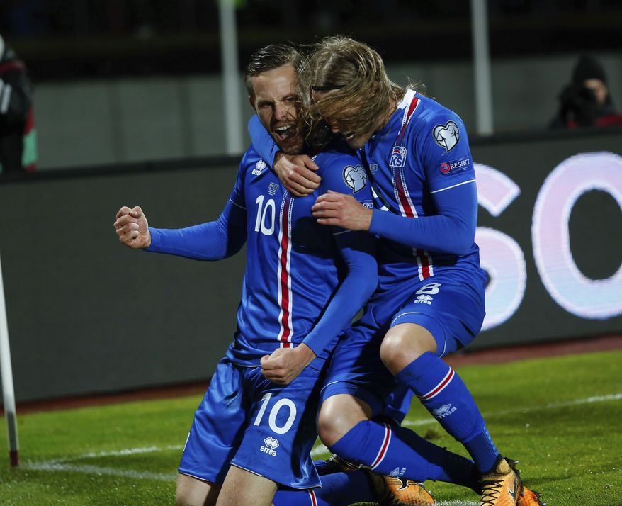 Iceland's Gylfi Sigurdsson, left, celebrates with teammate Birkir Bjarnason after scoring against Kosovo, during the World Cup Group I qualifying soccer match between Iceland and Kosovo in Reykjavik, Iceland, Monday Oct. 9, 2017. (AP Photo/Brynjar Gunnarsson).