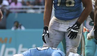 Tennessee Titans offensive tackle Jack Conklin (78) looks down at quarterback Matt Cassel (16), as he takes his time to get up after he was sacked during the second half of an NFL football game, Sunday, Oct. 8, 2017, in Miami Gardens, Fla. The Dolphins defeated the Titans 16-10. (AP Photo/Joel Auerbach)