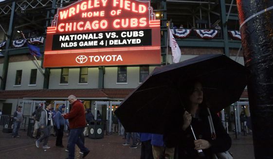 Fans leave Wrigley Field after Game 4 of baseball&#39;s National League Division Series between the Chicago Cubs and the Washington Nationals was postponed until Wednesday due to rain, Tuesday, Oct. 10, 2017, in Chicago. (AP Photo/Nam Y. Huh)