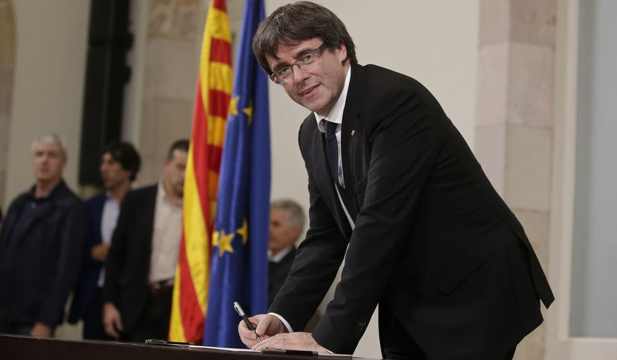 Catalan regional President Carles Puigdemont signed an independence declaration after a parliamentary session in Barcelona, Spain, on Tuesday. Mr. Puigdemont says he has a mandate to declare independence for the northeastern region but proposes waiting &quot;a few weeks&quot; in order to facilitate a dialogue. (Associated Press)