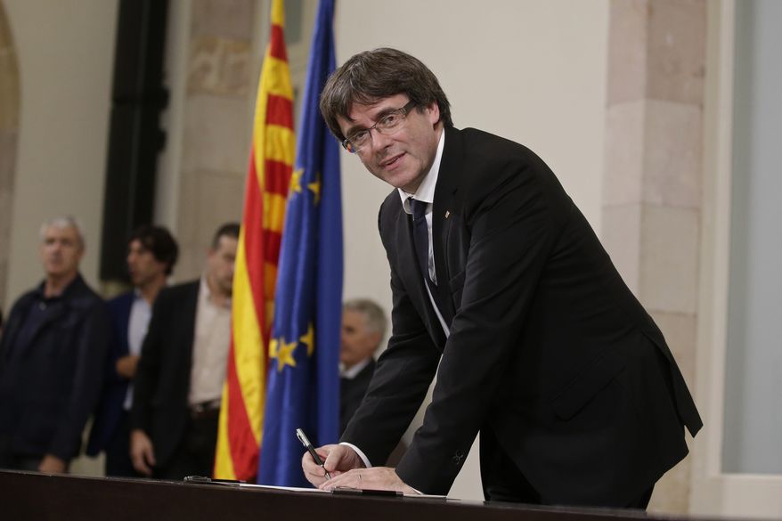 Catalan regional President Carles Puigdemont signed an independence declaration after a parliamentary session in Barcelona, Spain, on Tuesday. Mr. Puigdemont says he has a mandate to declare independence for the northeastern region but proposes waiting &quot;a few weeks&quot; in order to facilitate a dialogue. (Associated Press)