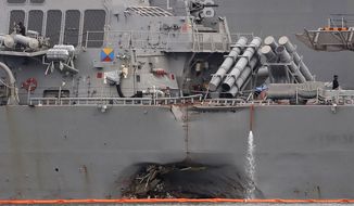 FILE - In this Aug. 22, 2017 file photo, the damaged port aft hull of the USS John S. McCain is visible while docked at Singapore&#39;s Changi naval base in Singapore. The U.S. Navy said in a statement Wednesday, Oct. 11, 2017, that the Navy has relieved of duties the commander and executive officer of the USS John S. McCain, which collided with an oil tanker near Singapore in August. (AP Photo/Wong Maye-E, File)