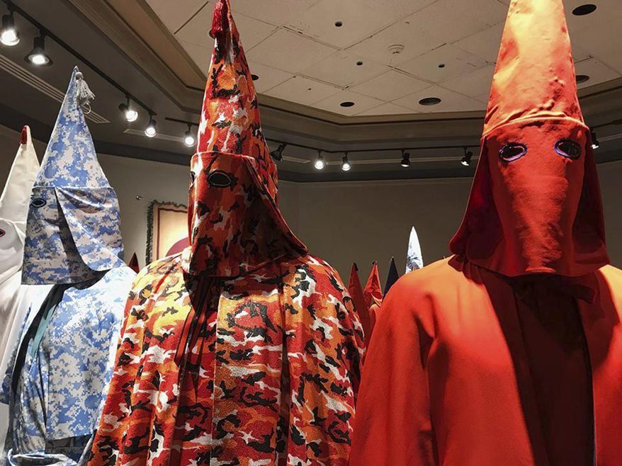 In this Sept. 21, 2017 file hoto, KKK robes are on display as part of Baltimore artist Paul Rucker's installation entitled "Rewind" at York College's Wolf Hall in York, Pa. (Ivey DeJesus/PennLive.com via AP)