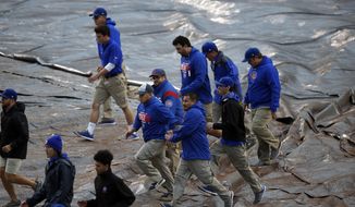 Ground crew cover the infield before Game 4 of baseball&#39;s National League Division Series between the Chicago Cubs and the Washington Nationals, Tuesday, Oct. 10, 2017, in Chicago. (AP Photo/Charles Rex Arbogast)