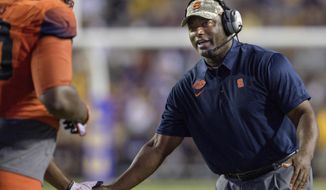 FILE - In this Sept. 23, 2017, file photo, Syracuse coach Dino Babers celebrates a touchdown with his team against LSU in the second half of an NCAA college football game in Baton Rouge, La, Syracuse has beaten one ranked team in the short tenure of coach Dino Babers. The Orange have a chance to notch another when No. 2 Clemson comes to town on Friday night.  (AP Photo/Matthew Hinton, File)