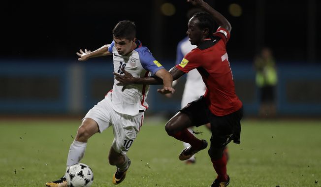United States&#x27; Christian Pulisic, left, fight for the ball with Trinidad and Tobago&#x27;s Nathan Lewis during a 2018 World Cup qualifying soccer match in Couva, Trinidad, Tuesday, Oct. 10, 2017. (AP Photo/Rebecca Blackwell)