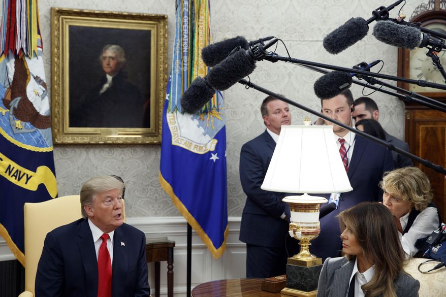 First lady Melania Trump listens as President Donald Trump speaks with reporters during a meeting with Canadian Prime Minister Justin Trudeau in the Oval Office of the White House, Wednesday, Oct. 11, 2017, in Washington. (AP Photo/Evan Vucci)