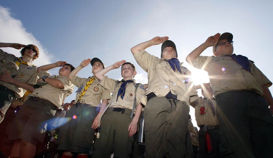 FILE - In this Saturday morning, May 21, 2011 file photo, Boy Scouts salute during a "camporee" in Sea Girt, N.J. The Wednesday, Oct. 11, 2017 Boy Scouts of America announcement to admit girls throughout its ranks will transform what has been a mostly cordial relationship between the two iconic youth groups since the Girl Scouts of the USA was founded in 1912, two years after the Boy Scouts. (AP Photo/Mel Evans)