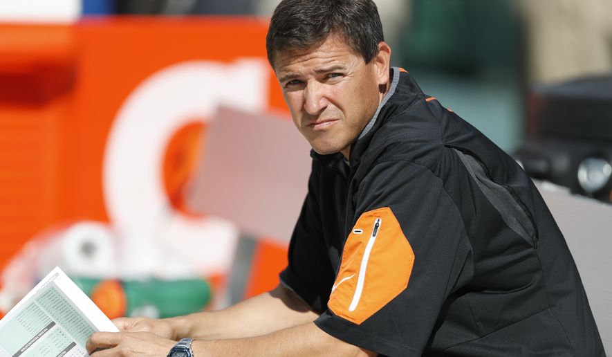 FILE - In this Sept. 24, 2017, file photo, Cincinnati Bengals offensive coordinator Bill Lazor looks over a lineup before an NFL football game against the Green Bay Packers, in Green Bay, Wis. Throughout their history, the Bengals have been reluctant to make big changes, especially during a season. They went out of character and changed offensive coordinators after two games, and it's made all the difference, changing them from a winless team into an AFC North contender. (AP Photo/Matt Ludtke, File)