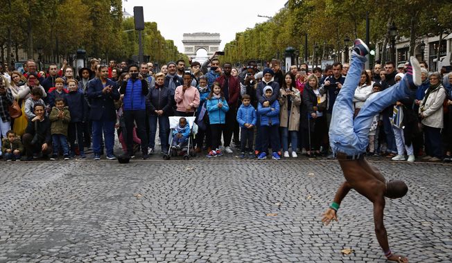FILE - In this Oct.1 2017 file photo, people watch a dancing performance on the champs Elysees avenue during the &amp;quot;day without cars&amp;quot;, in Paris. In its latest initiative to reduce pollution, Paris City Hall is planning to ban gas-powered cars by 2030. The controversial move follows Mayor Anne Hidalgo&#x27;s plan to ban all diesel cars from the city by 2024, when Paris will host the Summer Olympics.(AP Photo/Thiabult Camus, FILE)