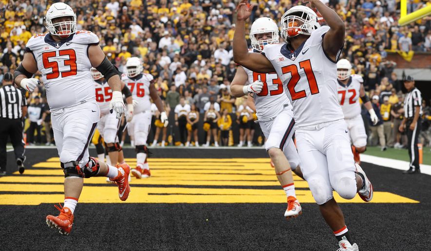 FILE - In this Oct. 7, 2017, file photo, Illinois running back Ra'Von Bonner (21) celebrates after scoring on a two-yard touchdown run during the first half of an NCAA college football game against Iowa in Iowa City, Iowa. Illinois piled up 200 rushing yards in a loss at Iowa last weekend, using primarily three running backs to do it. The Illini are hoping to ride the run to a win at home against Rutgers this Saturday. (AP Photo/Charlie Neibergall, File)